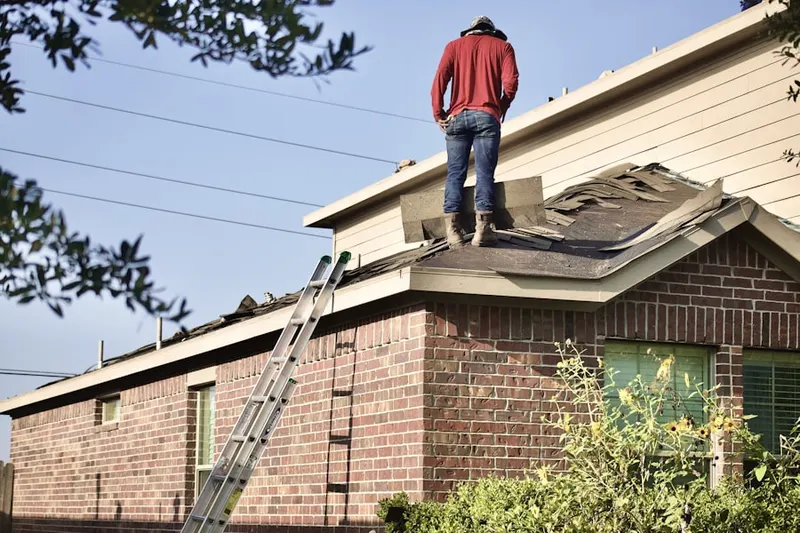 Professional roofer working on a residential roof in Patton